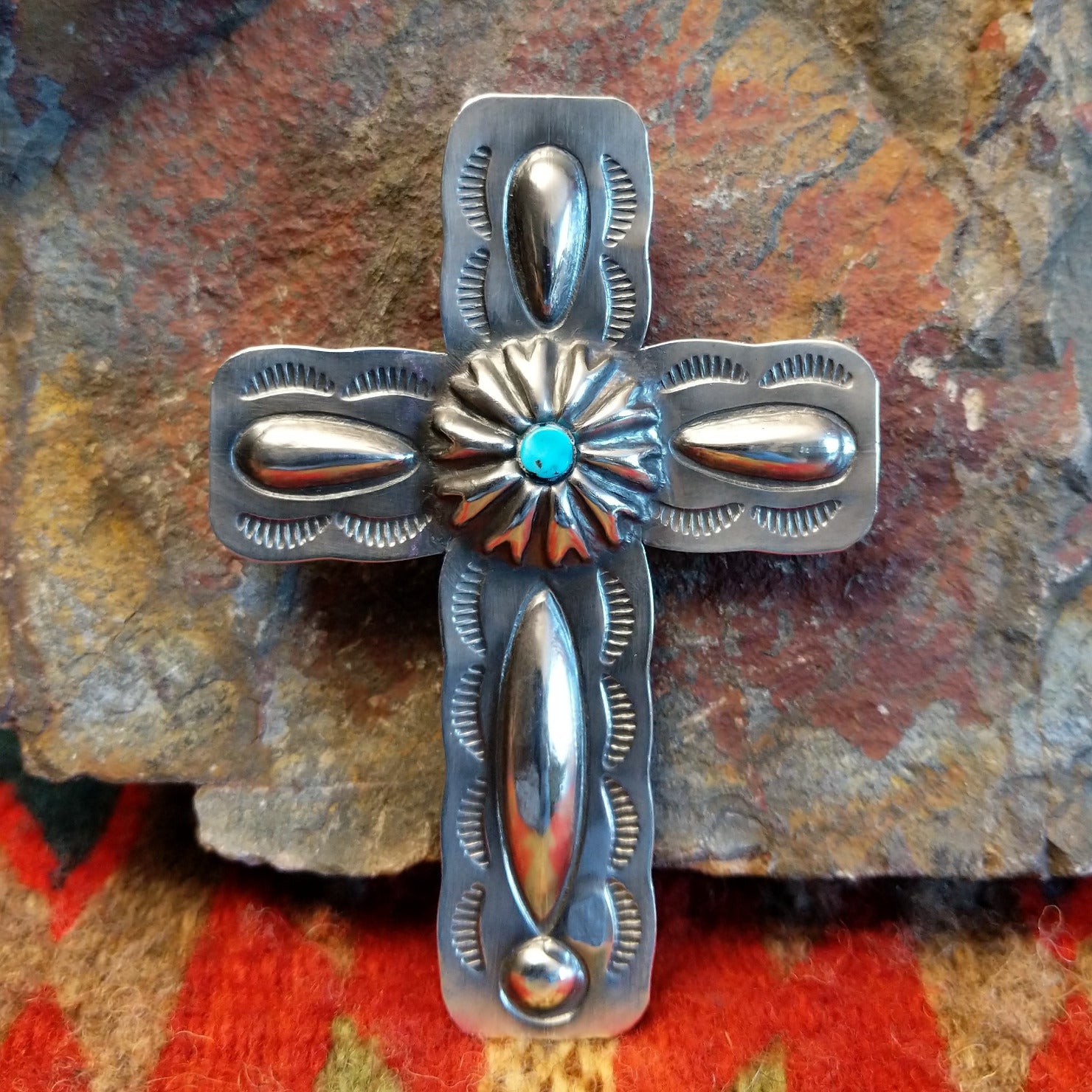 Sterling silver stamped cross pendant with small turquoise by Navajo artisan Charlene Yazzie.