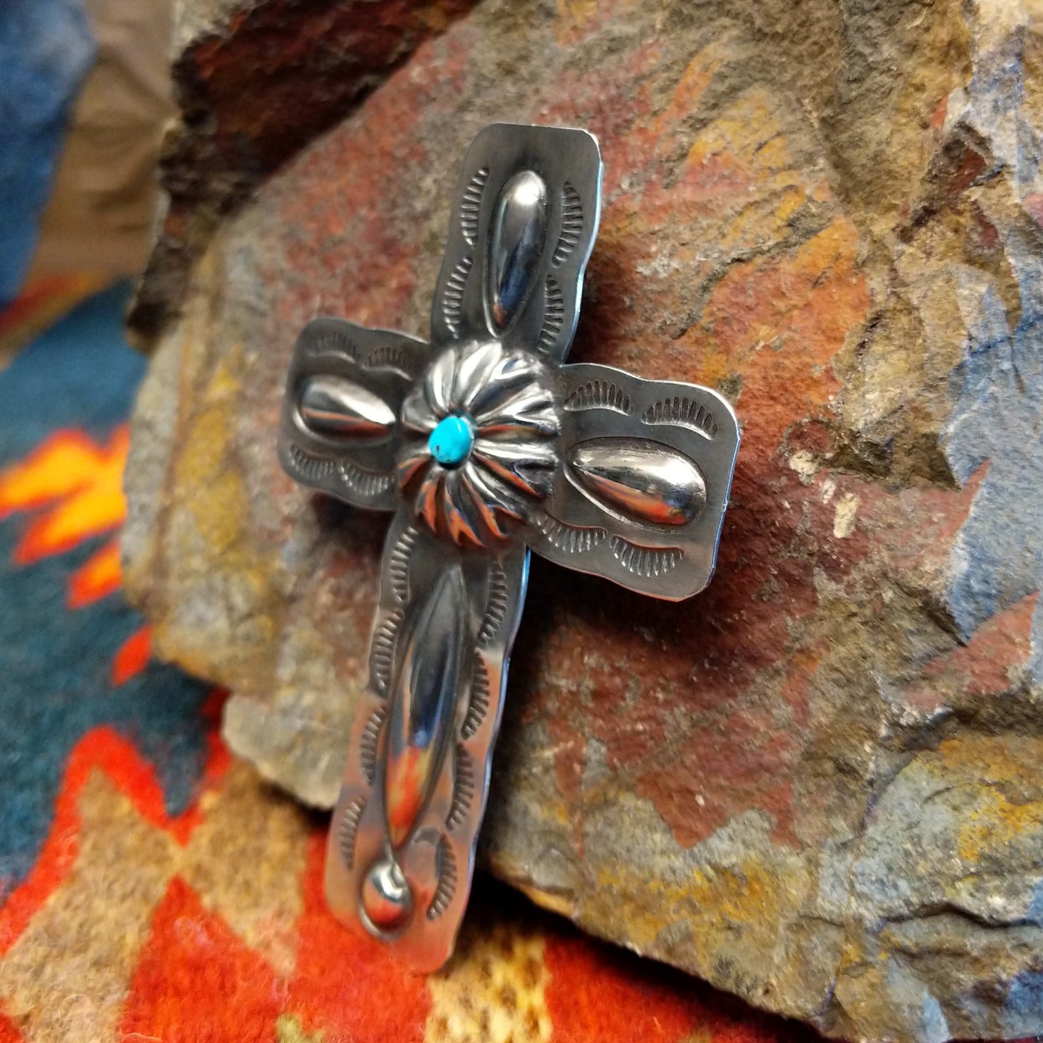 Sterling silver stamped cross pendant with small turquoise by Navajo artisan Charlene Yazzie., right side view