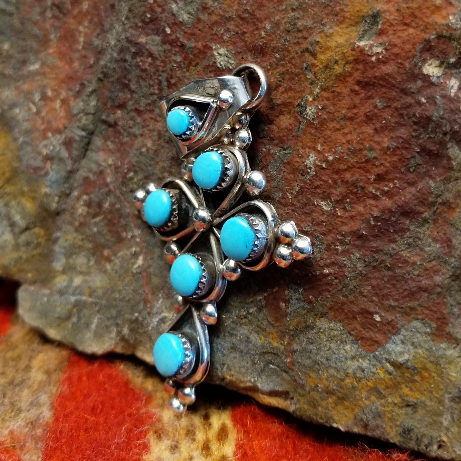 Sterling silver cross pendant with snake eye turquoise stones by Zuni artisan L.B. , side view
