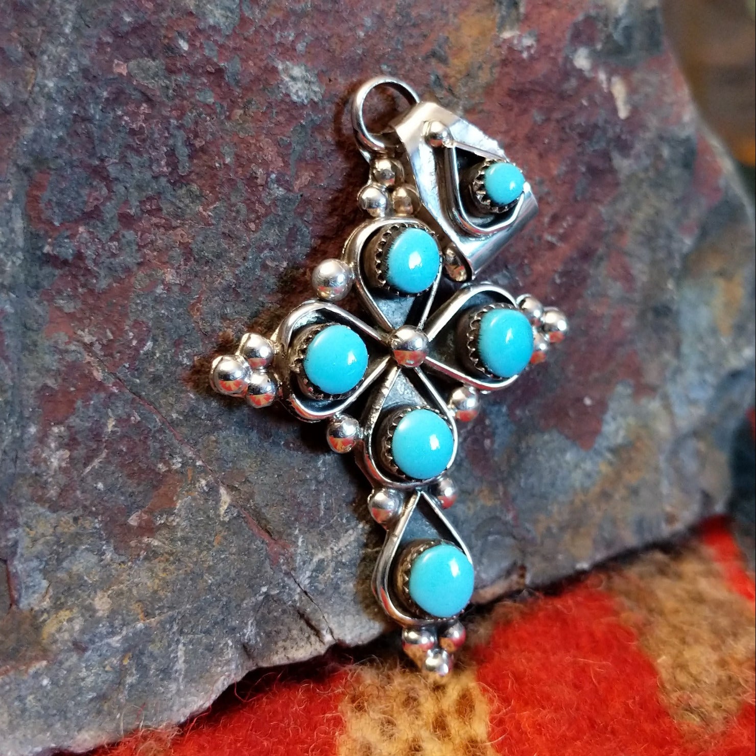 Sterling silver cross pendant with snake eye turquoise stones by Zuni artisan L.B. , showing bale in different position