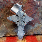Sterling silver cross pendant with snake eye turquoise stones by Zuni artisan L.B., back view showing artisan signature