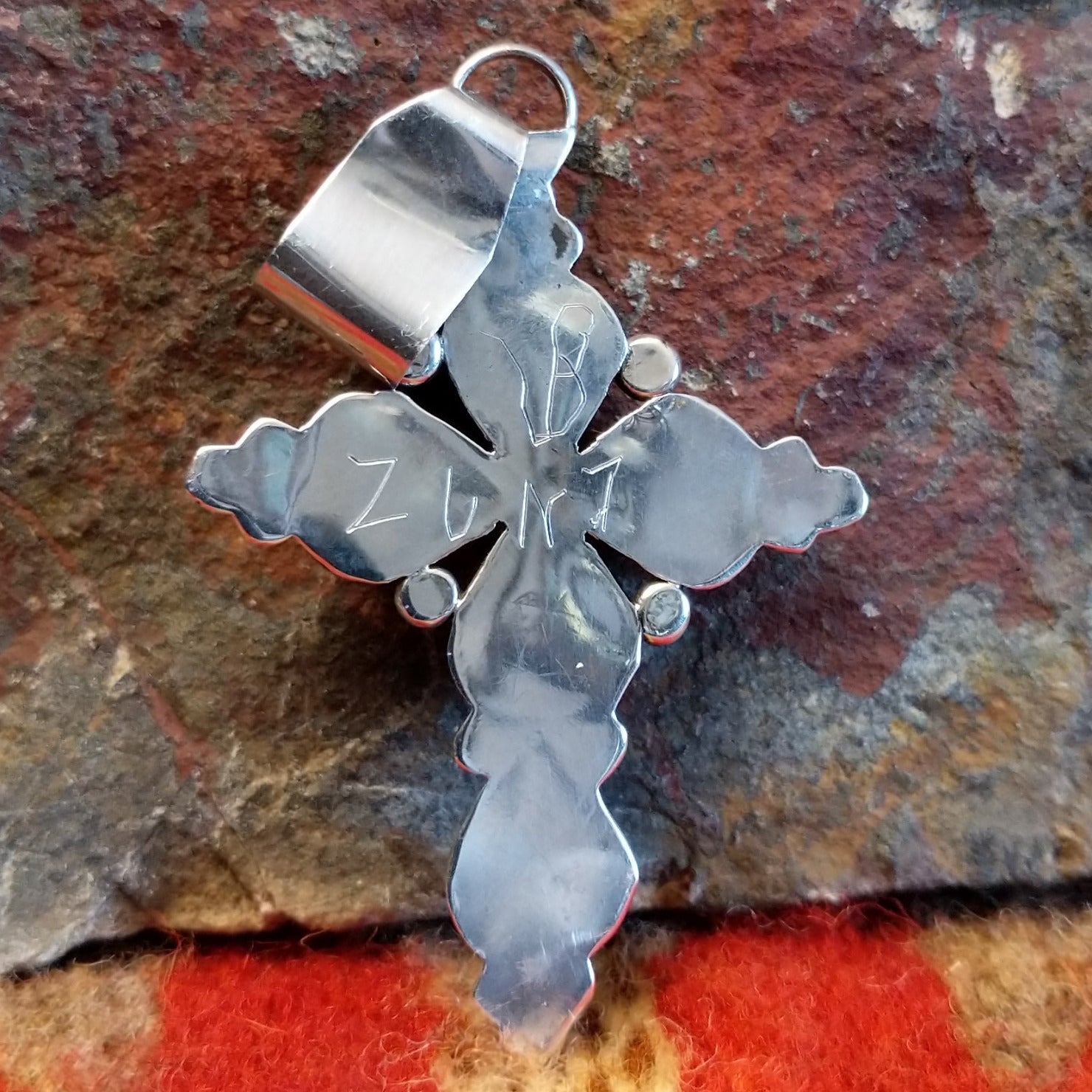 Sterling silver cross pendant with snake eye turquoise stones by Zuni artisan L.B., back view showing artisan signature