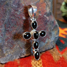 Handmade Navajo silver cross pendant featuring a black onyx stone by Ann Curley.