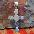 Handmade Navajo silver cross pendant featuring a black onyx stone by Ann Curley, back view showing artisan signature