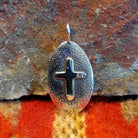 Oval sterling silver pendant with central cross by Navajo artisan Raymond Coriz.
