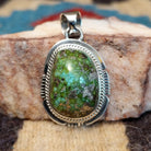 Domed sterling silver pendant featuring a polished Sonoran Gold turquoise stone with blue-green coloring and natural golden matrix, handcrafted by Navajo artist Burt Francisco. Front View.