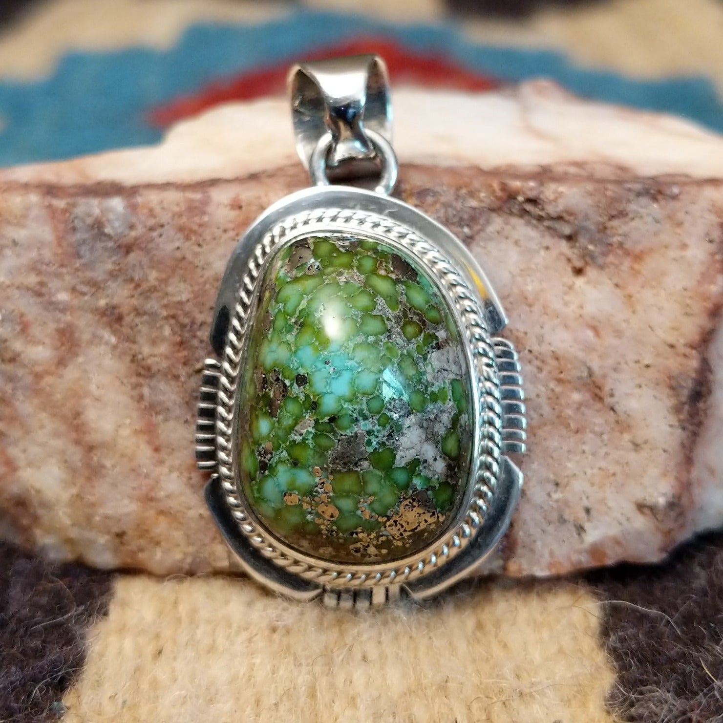 Domed sterling silver pendant featuring a polished Sonoran Gold turquoise stone with blue-green coloring and natural golden matrix, handcrafted by Navajo artist Burt Francisco. Front View.