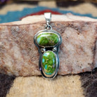 Sterling silver pendant with arranged Sonoran Gold turquoise stones displaying blue-green hues and natural golden matrix, handcrafted by artisan L.P.  Front view.