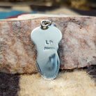 Sterling silver pendant with arranged Sonoran Gold turquoise stones displaying blue-green hues and natural golden matrix, handcrafted by artisan L.P.  Back view with artisan and silver stamp.