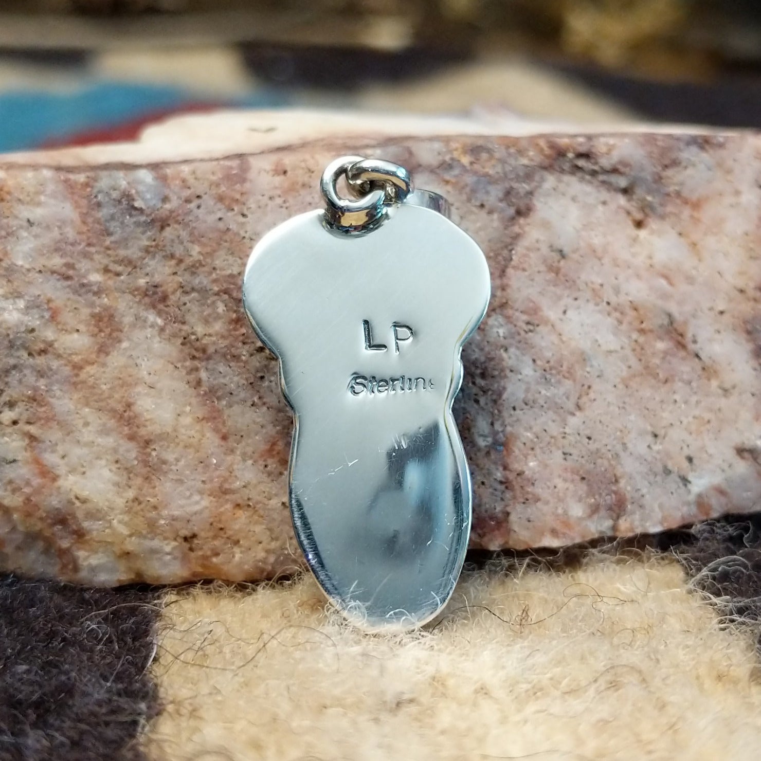 Sterling silver pendant with arranged Sonoran Gold turquoise stones displaying blue-green hues and natural golden matrix, handcrafted by artisan L.P.  Back view with artisan and silver stamp.