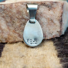 Ovoid sterling silver pendant featuring a polished Sonoran Gold turquoise stone with blue-green color and golden matrix, handcrafted by Native American artist Fred Guerro Jr.  Back view with artisan and silver stamp.