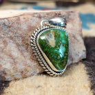 Triangular sterling silver pendant featuring a polished Sonoran Gold turquoise stone with blue-green tones and natural golden matrix, handcrafted by Navajo artist Artie Yellowhorse.  Side view.