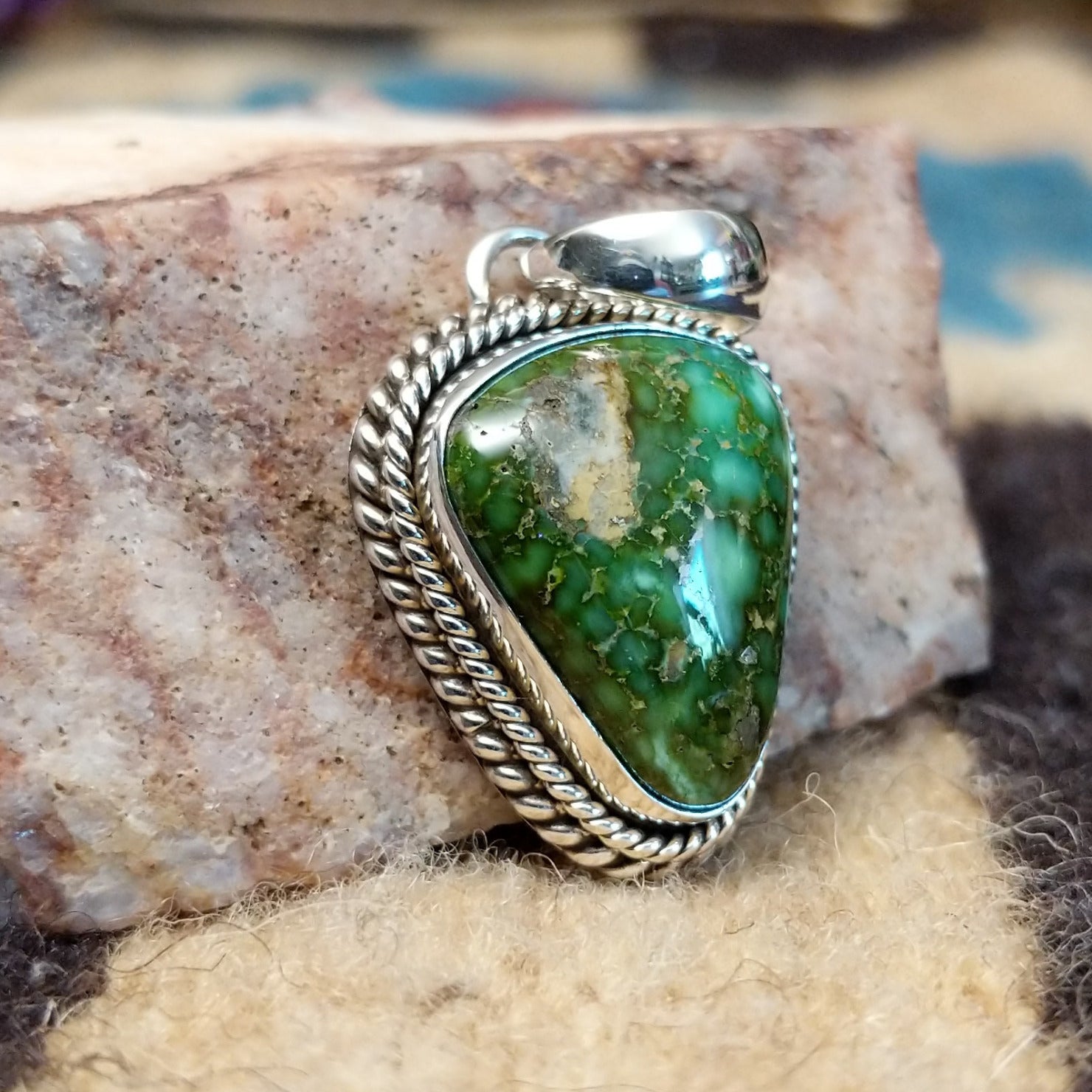 Triangular sterling silver pendant featuring a polished Sonoran Gold turquoise stone with blue-green tones and natural golden matrix, handcrafted by Navajo artist Artie Yellowhorse.  Side view.