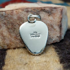 Triangular sterling silver pendant featuring a polished Sonoran Gold turquoise stone with blue-green tones and natural golden matrix, handcrafted by Navajo artist Artie Yellowhorse.  Back view with artisan and silver stamp.