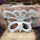 Sterling silver butterfly pin featuring Sonoran Gold turquoise stones with blue-green hues and natural golden matrix, handcrafted by Native American artist Francis Jones.  Back view with artisan and silver stamp.