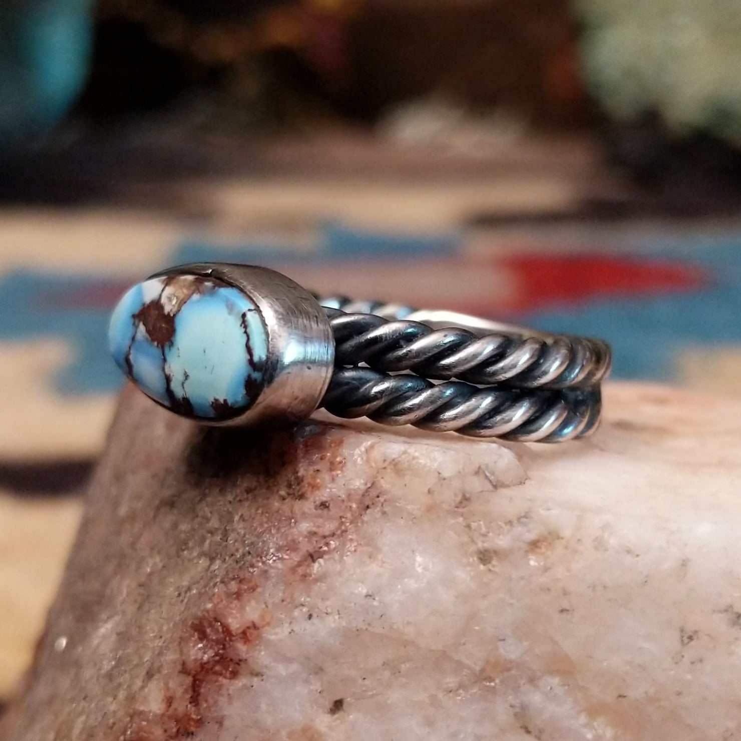 Navajo sterling silver ring with an oval Golden Hills turquoise stone and twisted silver band in a classic Southwestern design.  Side view.
