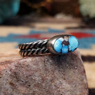 Navajo sterling silver ring with an oval Golden Hills turquoise stone and twisted silver band in a classic Southwestern design.  Side view.