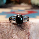Sterling silver split-band ring by Raymond Coriz featuring a polished black onyx stone in a sleek Southwestern design.  Front view.