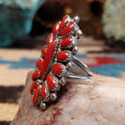 Sterling silver floral coral ring by Lorraine Waatsa featuring a vibrant red coral stone in a detailed Southwestern design.  Side view.