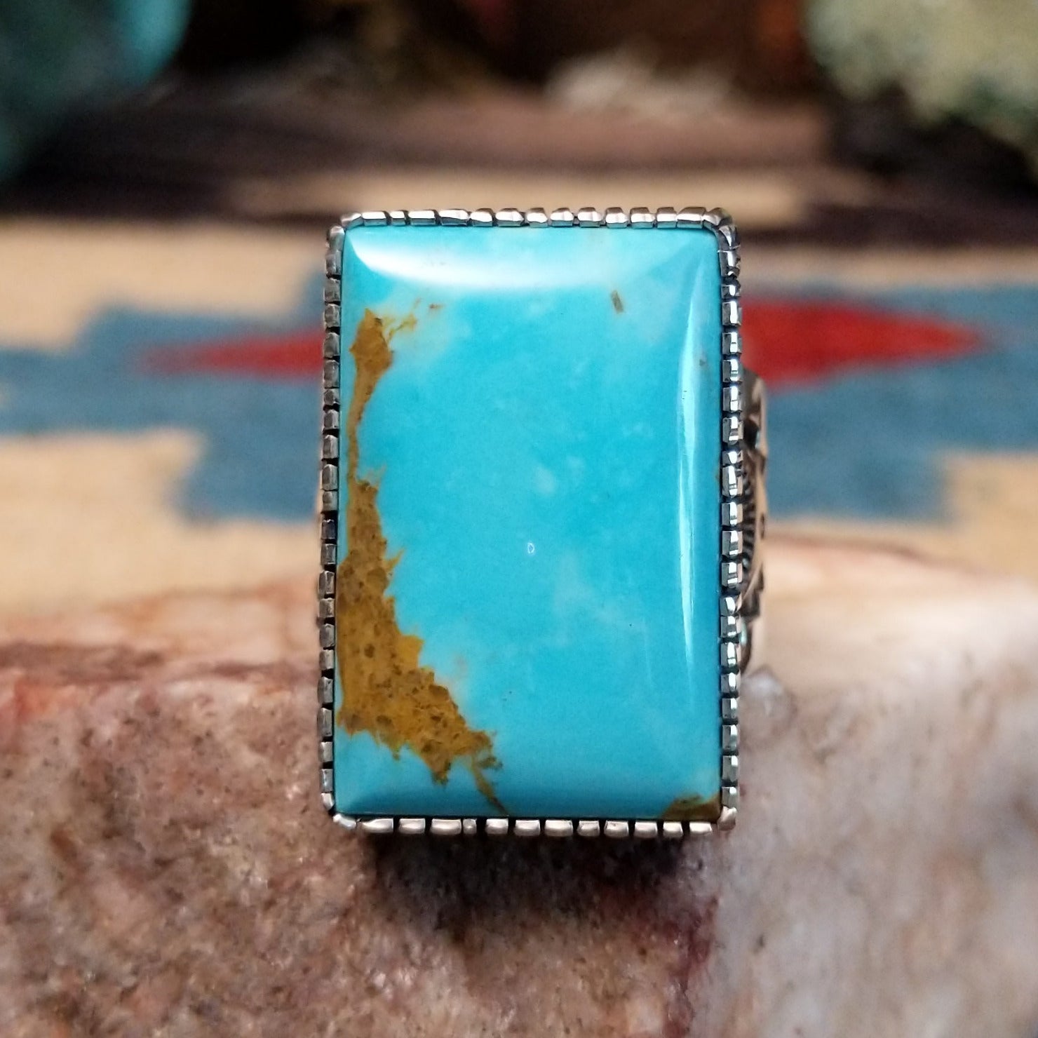 Sterling silver rectangular turquoise ring by Joe Paul featuring a vivid blue turquoise stone in a bold Southwestern design.  Front view.
