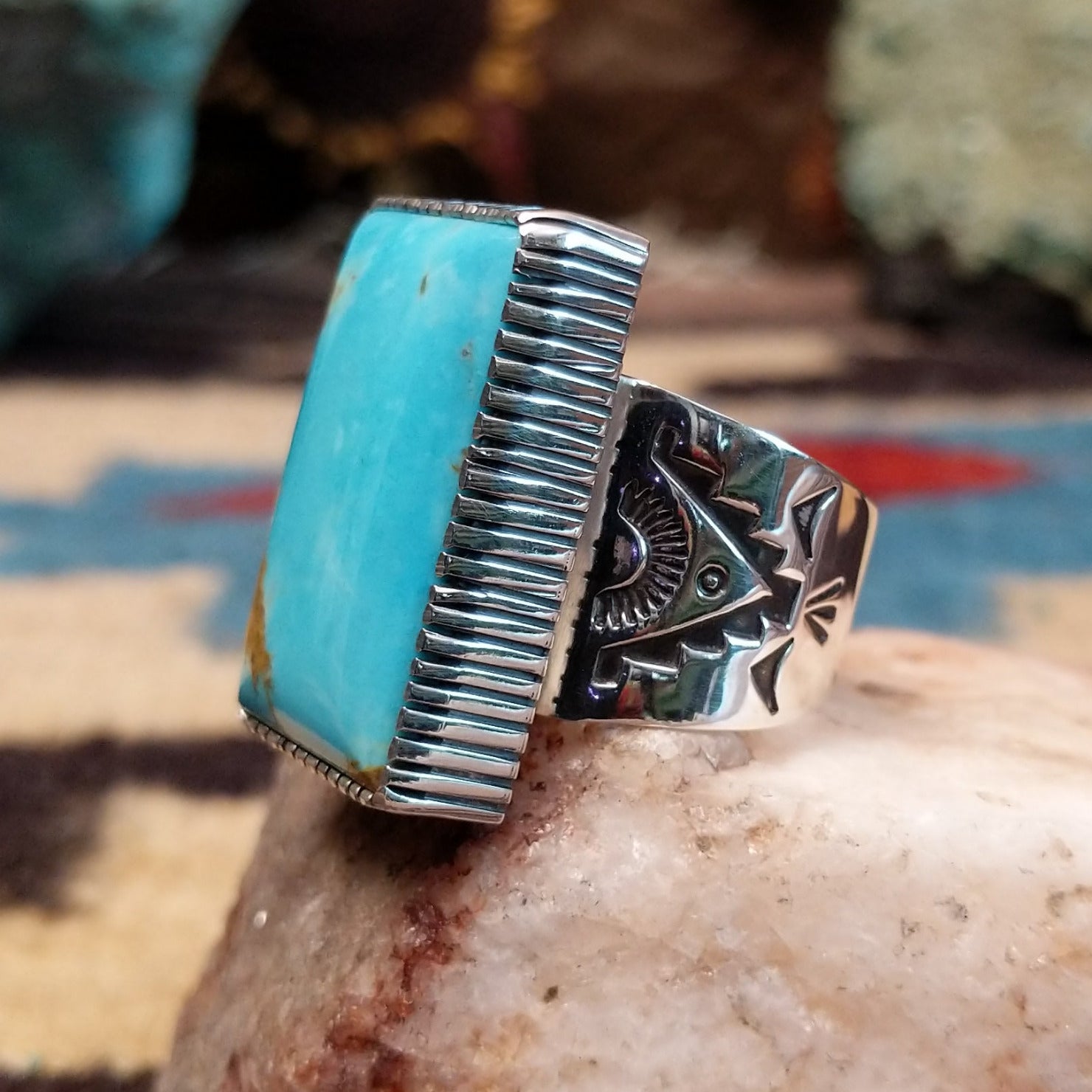 Sterling silver rectangular turquoise ring by Joe Paul featuring a vivid blue turquoise stone in a bold Southwestern design.  Side view.