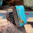 Sterling silver rectangular turquoise ring by Joe Paul featuring a vivid blue turquoise stone in a bold Southwestern design.  Side view.