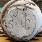 Medium flared white horsehair pottery vase by Jim Calhoun with a polished finish, smoky organic patterns, and a softly flared rim in Southwestern style.  Underside view of artisan initials.