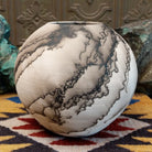 Medium globe-shaped white horsehair pottery vase by local artist Jim Calhoun featuring smoky organic patterns, a polished finish, and Southwestern handcrafted design.