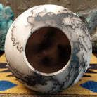 Medium globe-shaped white horsehair pottery vase by local artist Jim Calhoun featuring smoky organic patterns, a polished finish, and Southwestern handcrafted design.  Top view.