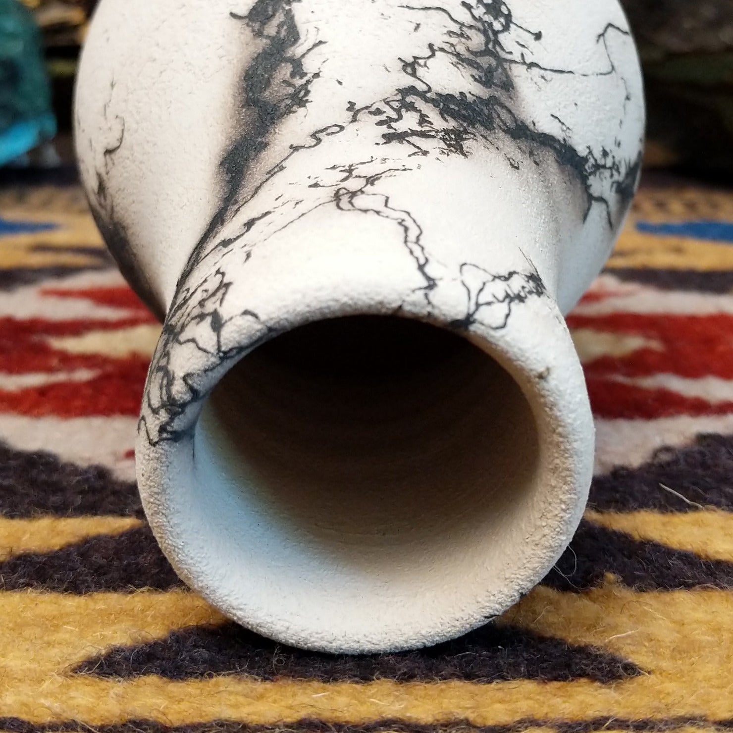Small chiminea-style white horsehair pottery vase by local artisan Jim Calhoun with smoky natural patterns, polished finish, and handcrafted Southwestern design.  Top view.