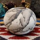 Small globe-shaped white horsehair pottery vase by local artisan Jim Calhoun featuring smoky organic markings, polished finish, and handcrafted Southwestern design.