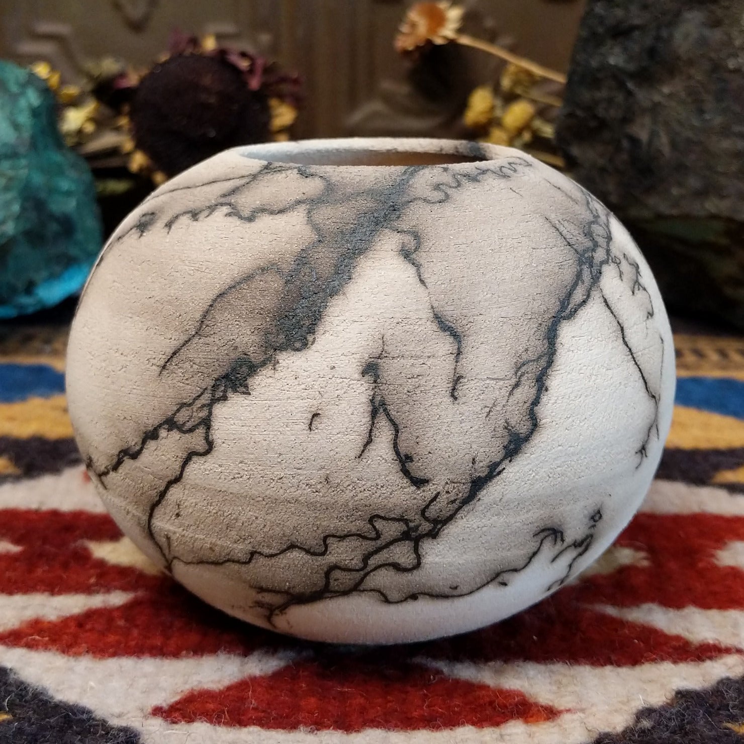 Small globe-shaped white horsehair pottery vase by local artisan Jim Calhoun featuring smoky organic markings, polished finish, and handcrafted Southwestern design.