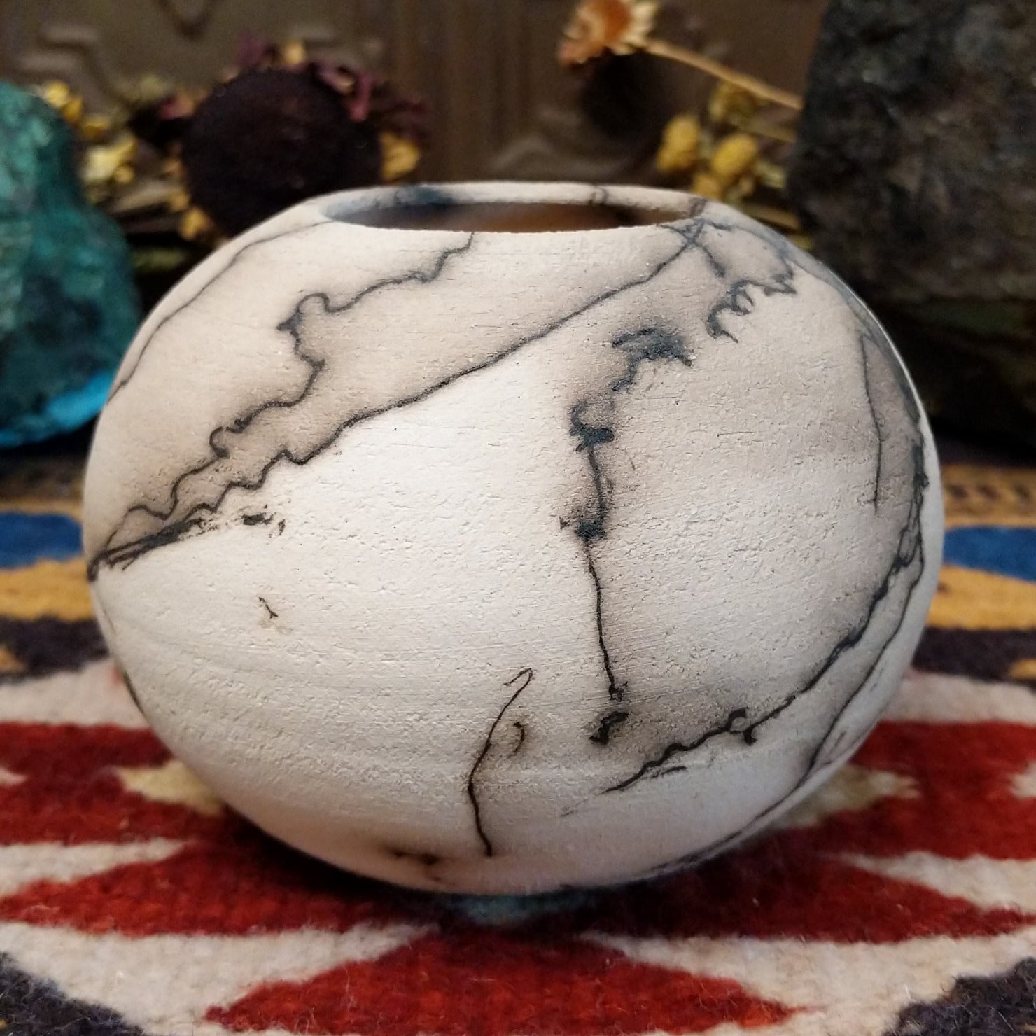 Small globe-shaped white horsehair pottery vase by local artisan Jim Calhoun featuring smoky organic markings, polished finish, and handcrafted Southwestern design.