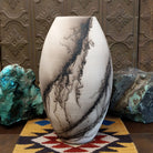 Large oval-shaped white horsehair pottery vase by local artisan Jim Calhoun featuring bold black smoky patterns, polished white finish, and handcrafted Southwestern design.