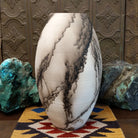 Large oval-shaped white horsehair pottery vase by local artisan Jim Calhoun featuring bold black smoky patterns, polished white finish, and handcrafted Southwestern design.