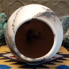 Large oval-shaped white horsehair pottery vase by local artisan Jim Calhoun featuring bold black smoky patterns, polished white finish, and handcrafted Southwestern design.  Top view.