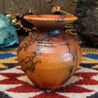 Small handcrafted terracotta horsehair vase with a rounded body and flared rim, decorated with black abstract horsehair firing patterns by artisan Jim Calhoun.