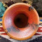Small handcrafted terracotta horsehair vase with a rounded body and flared rim, decorated with black abstract horsehair firing patterns by artisan Jim Calhoun.  Top view.