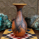 Flared terracotta horsehair vase handcrafted by local artisan Jim Calhoun, featuring a wide flared rim, earthy clay tones, and organic black horsehair fire patterns on the surface.