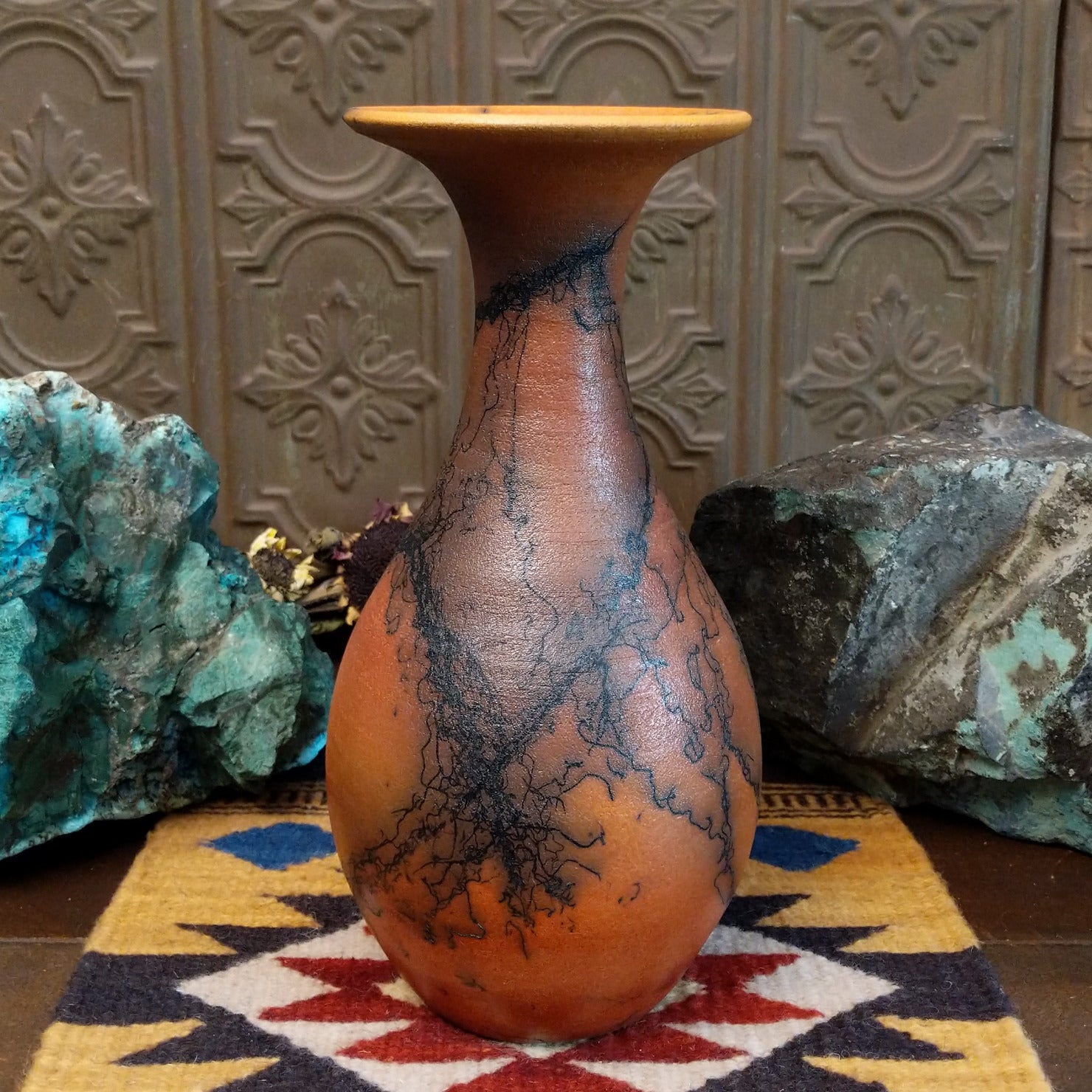 Flared terracotta horsehair vase handcrafted by local artisan Jim Calhoun, featuring a wide flared rim, earthy clay tones, and organic black horsehair fire patterns on the surface.