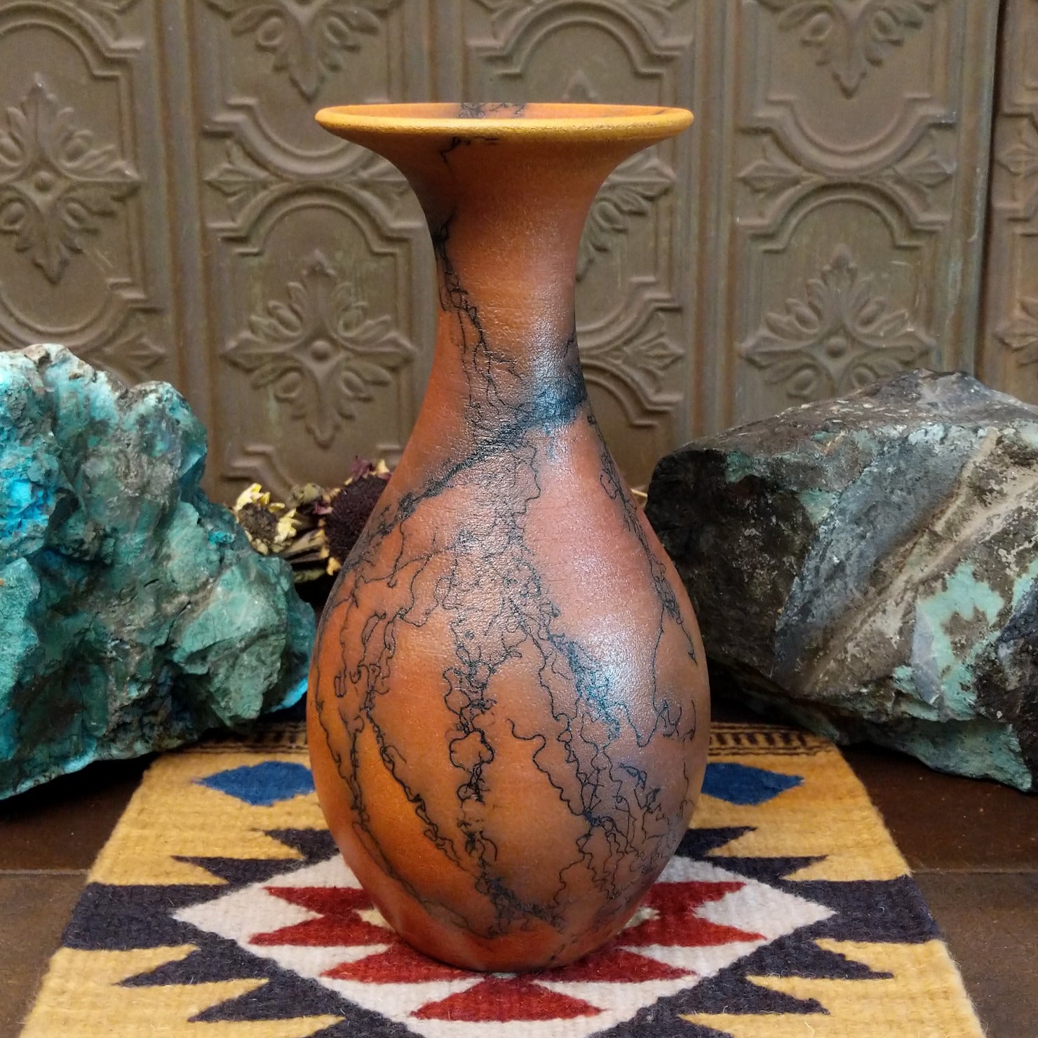Flared terracotta horsehair vase handcrafted by local artisan Jim Calhoun, featuring a wide flared rim, earthy clay tones, and organic black horsehair fire patterns on the surface.