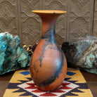 Flared terracotta horsehair vase handcrafted by local artisan Jim Calhoun, featuring a wide flared rim, earthy clay tones, and organic black horsehair fire patterns on the surface.