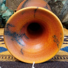 Flared terracotta horsehair vase handcrafted by local artisan Jim Calhoun, featuring a wide flared rim, earthy clay tones, and organic black horsehair fire patterns on the surface.  Top view.