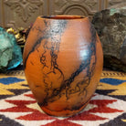 Small oval terracotta horsehair vase handcrafted by local artisan Jim Calhoun, featuring warm earthy clay tones and delicate black horsehair fire patterns on a smooth rounded surface.