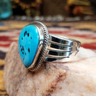 Handcrafted Navajo sterling silver ring by L.P. featuring a natural turquoise stone with traditional Southwestern silver detailing and a polished finish.  Side view.