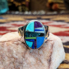 Handcrafted sterling silver oval ring by Eugene Davy featuring lapis, turquoise, charoite, mother of pearl, and gaspeite in a multistone Southwestern design.