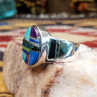 Handcrafted sterling silver oval ring by Eugene Davy featuring lapis, turquoise, charoite, mother of pearl, and gaspeite in a multistone Southwestern design.  Side view.
