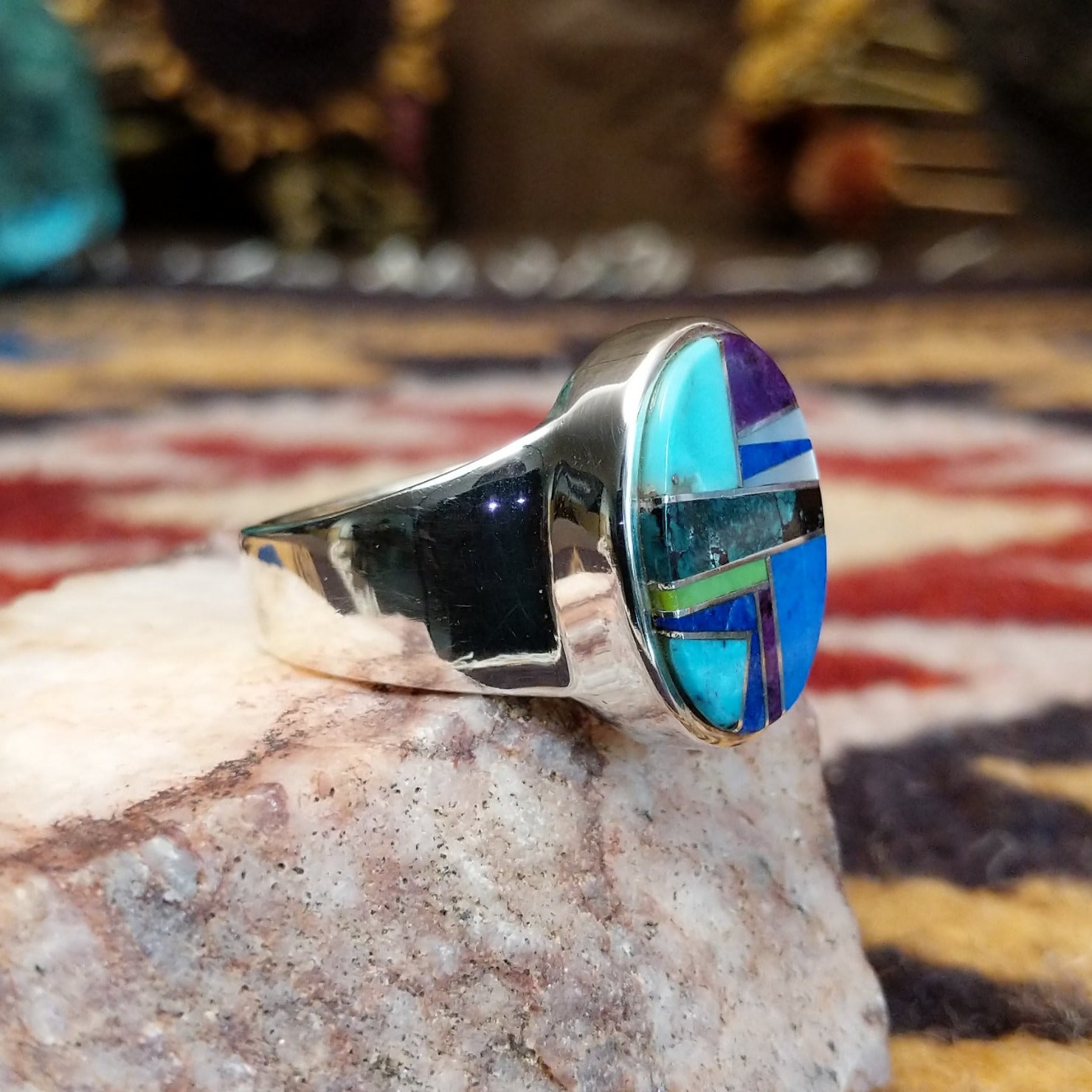 Handcrafted sterling silver oval ring by Eugene Davy featuring lapis, turquoise, charoite, mother of pearl, and gaspeite in a multistone Southwestern design.  Side view.