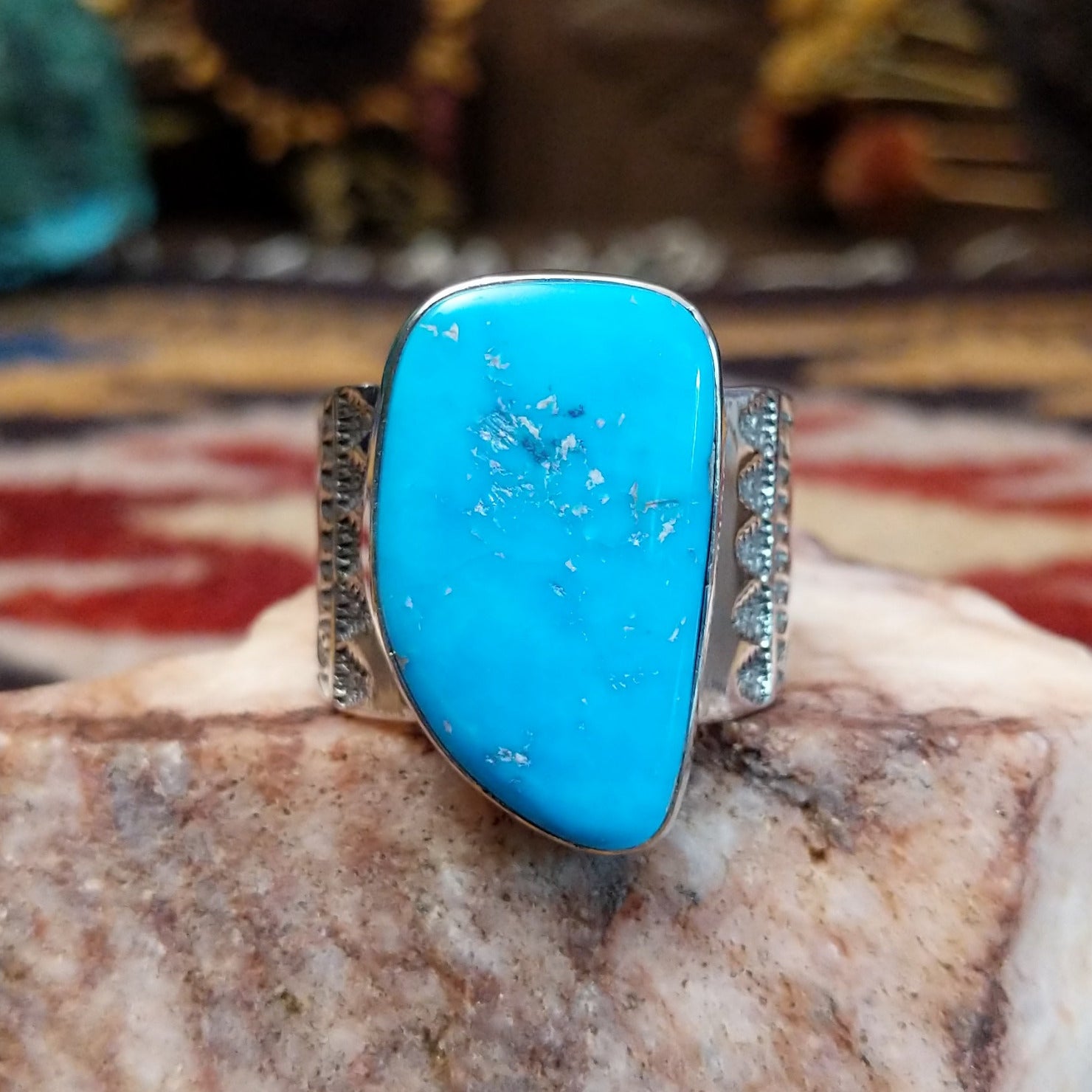 Handcrafted Navajo sterling silver ring by L.J. featuring a turquoise stone with traditional stamped silver detailing in a Southwestern design.