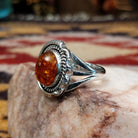Handcrafted sterling silver ring by Artie Yellowhorse featuring a warm amber stone in a polished Southwestern Native American design.  Side view.